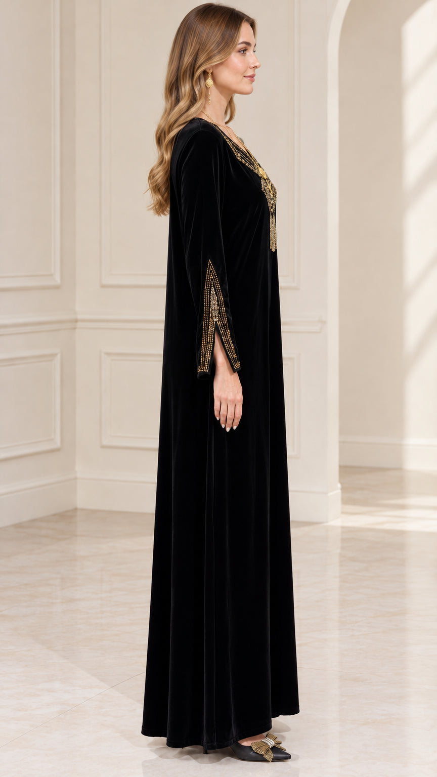 Side profile view of woman wearing flowing black velvet kaftan dress