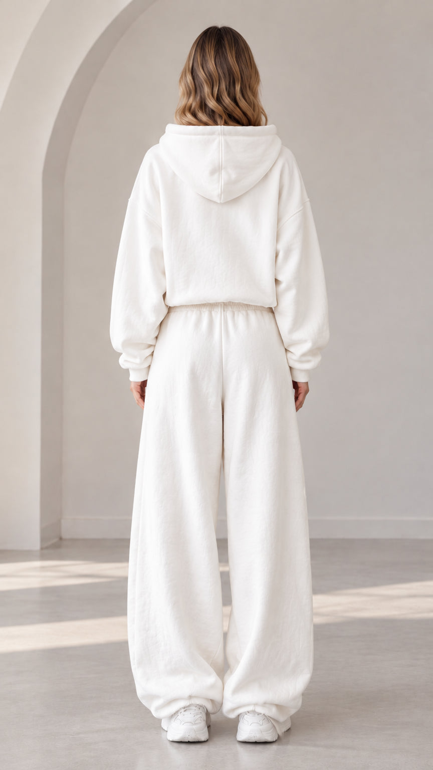 Back view of model wearing off-white oversized hooded tracksuit set
