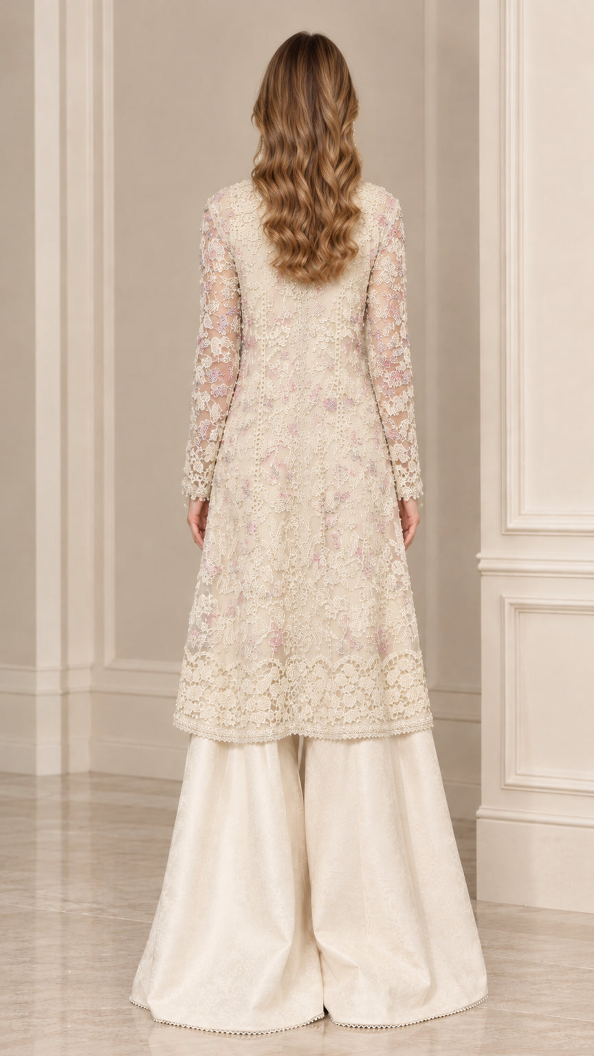 Back view of woman wearing elegant cream embroidered lace tunic and flared pants
