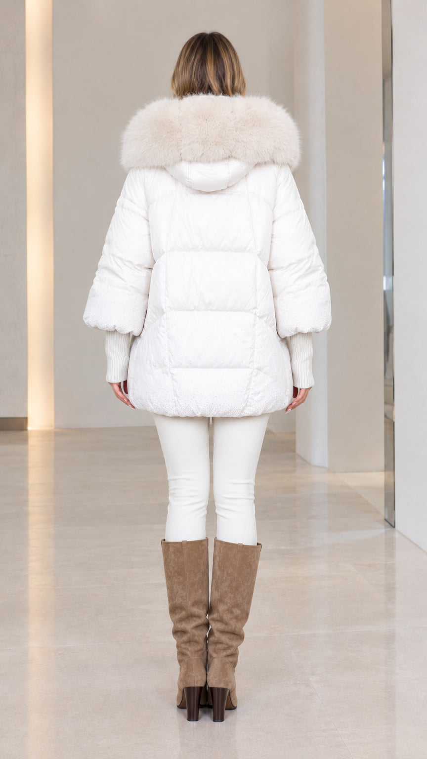 Back view of woman wearing white mid-length quilted winter coat with hood