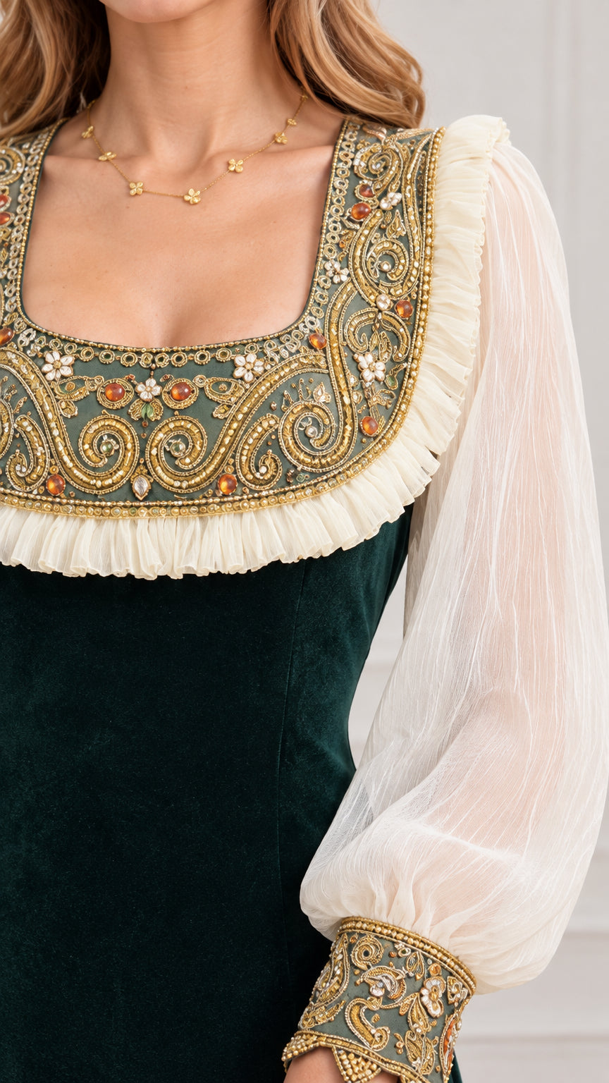 Close-up detail of ornate gold embroidered square neckline with ruffles and sheer sleeve cuff