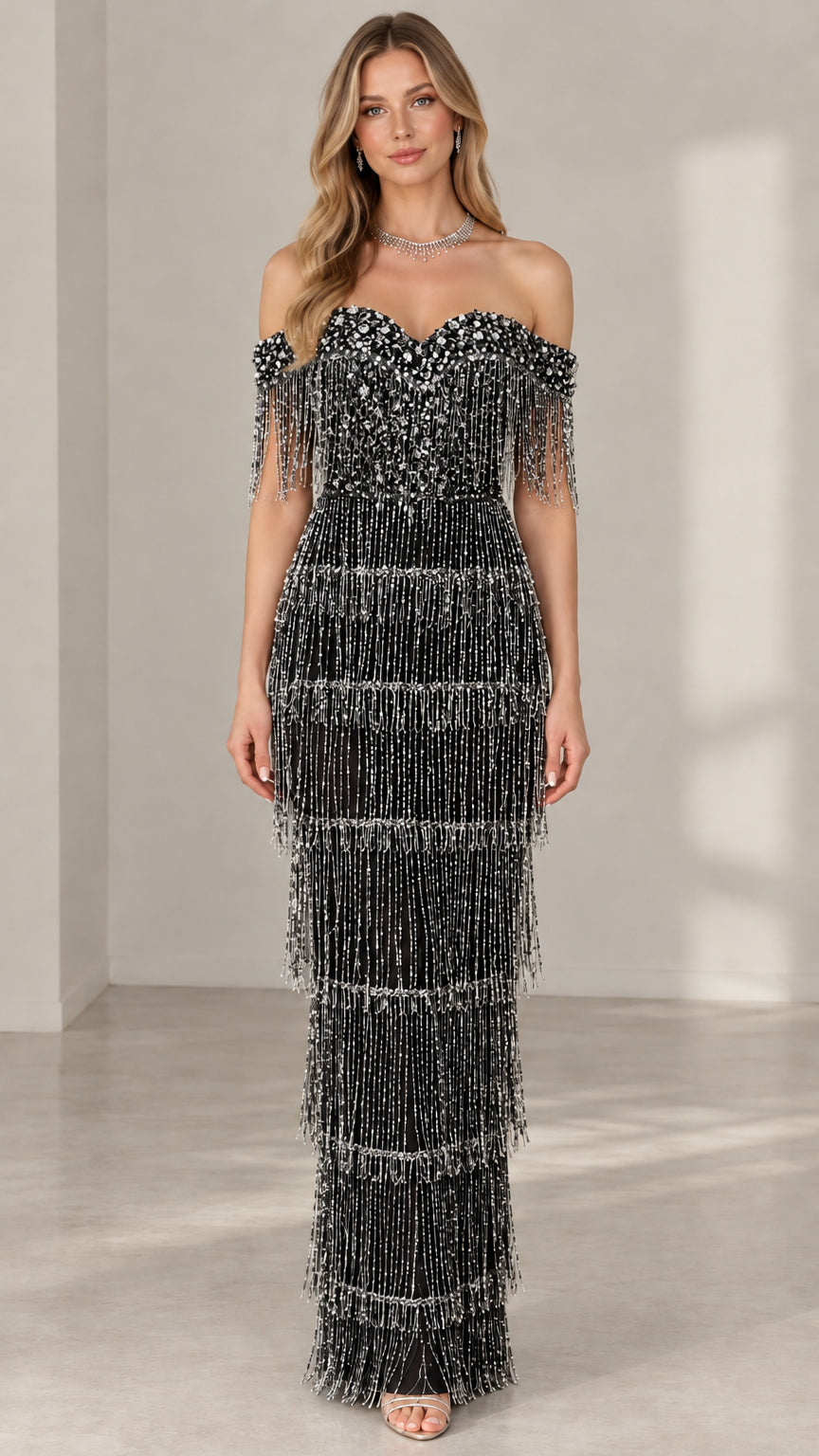 Model wearing black off-the-shoulder tiered beaded fringe maxi evening gown