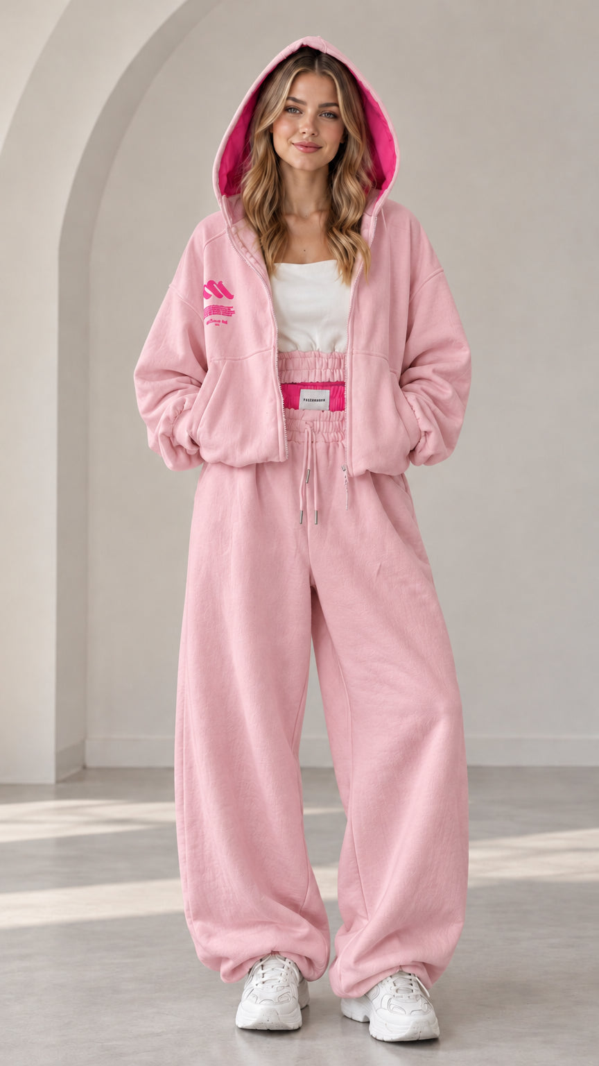 Model wearing light pink two-piece tracksuit set with contrast hot pink lined hood