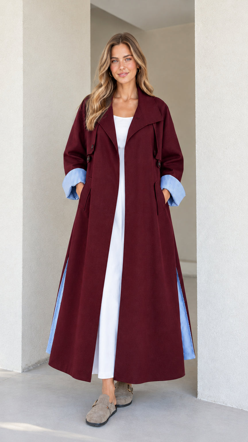 Model wearing the maxi trench duster in deep burgundy with blue striped turn-up cuffs